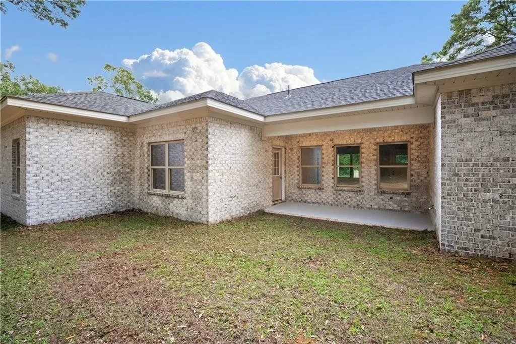 Rear exterior with a covered porch and lawn