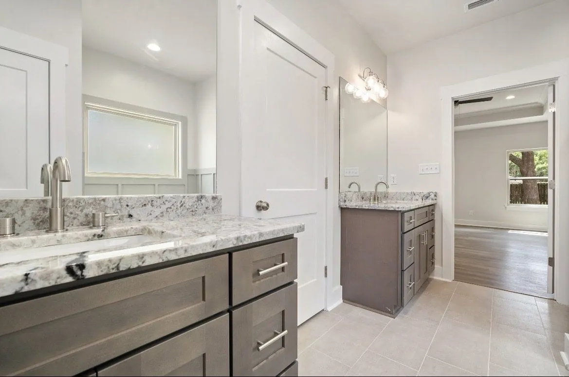 New home bathroom with a double vanity and tiled shower