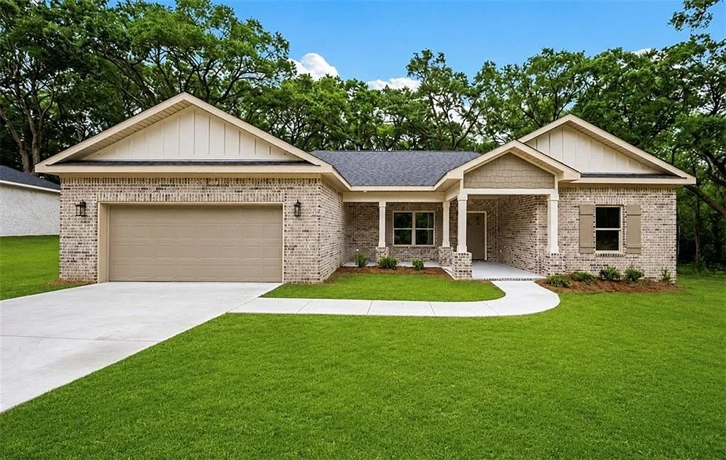 Front exterior with brick walls, a two-car garage and a curved walkway