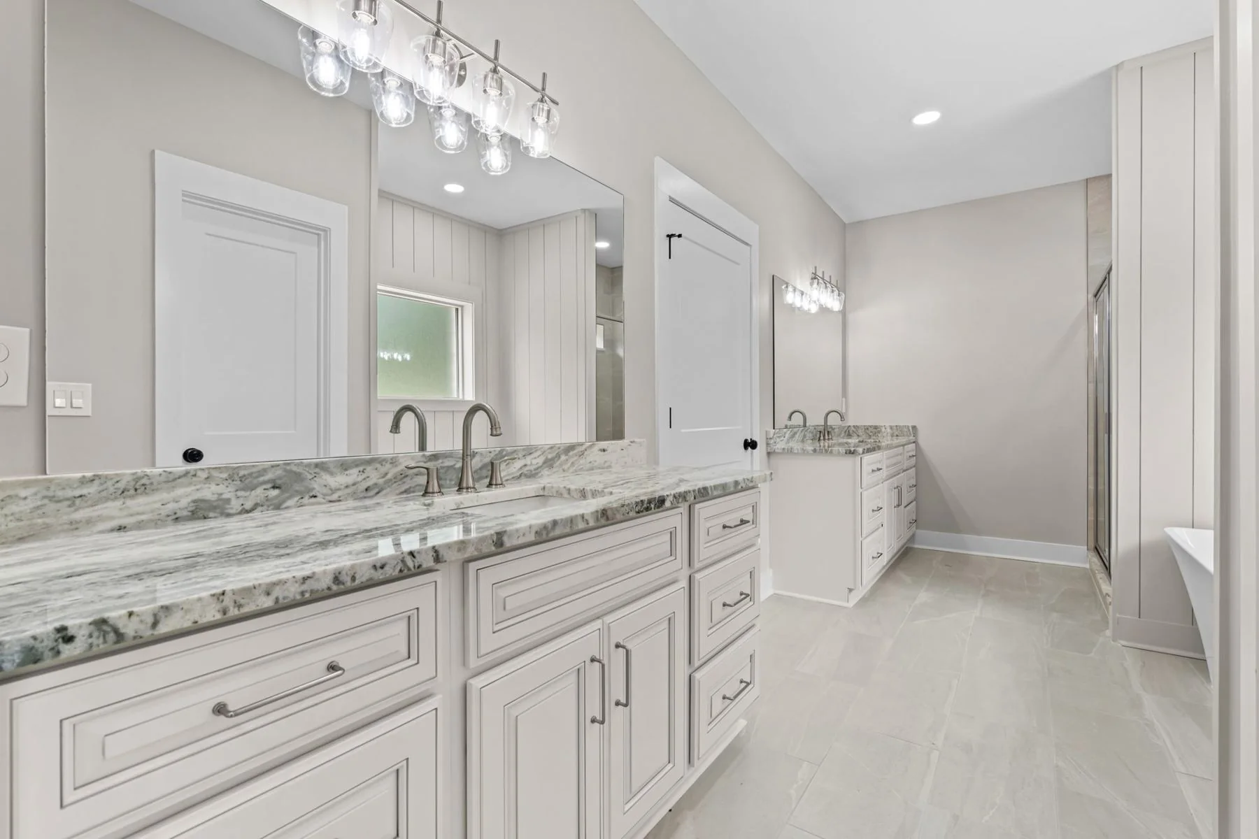 Bathroom at 1641 Woodberry Dr with double vanities and a tiled shower