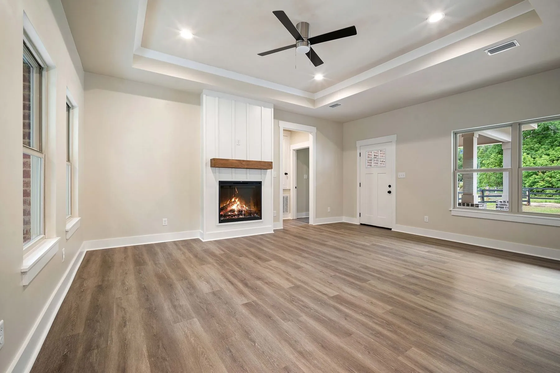 New home living room with a brick fireplace and ceiling fan