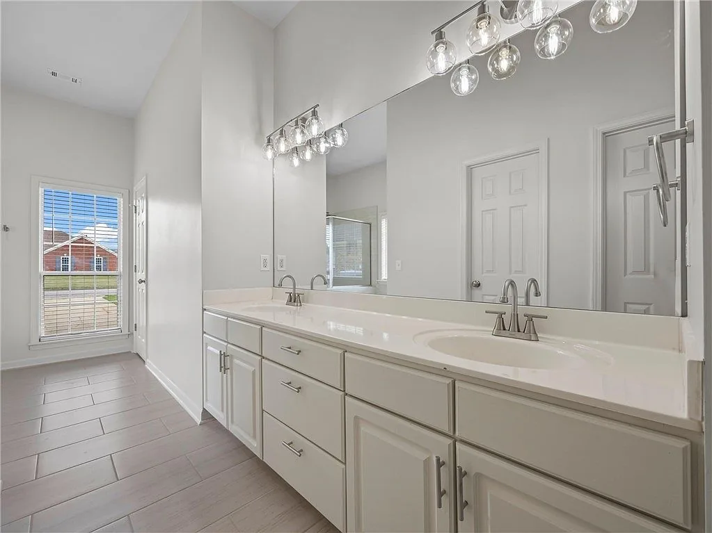 Bathroom with a long double vanity and wall mirrors