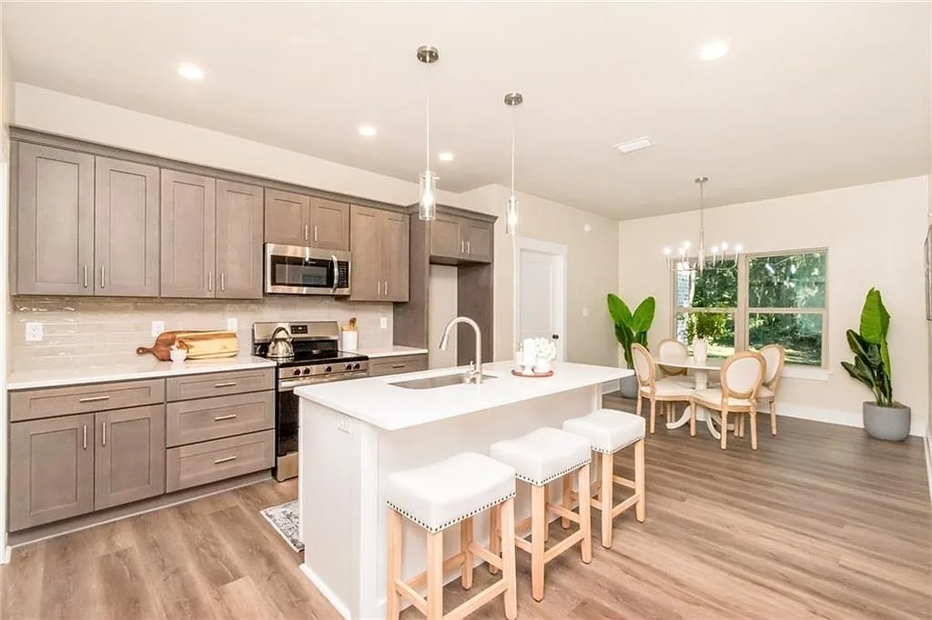Kitchen with a white island, wood cabinets and stainless appliances