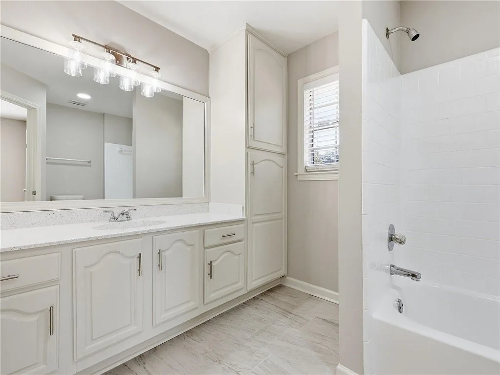 Bathroom with a white vanity and wall mirror