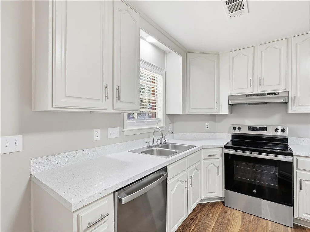 White kitchen cabinets, sink and stainless range