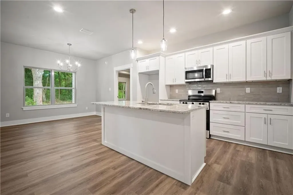 Open kitchen with a white island and pendant lights