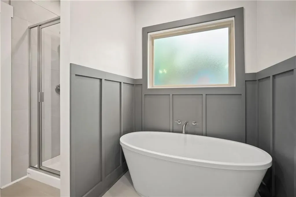 Bathroom with a freestanding tub and paneled walls